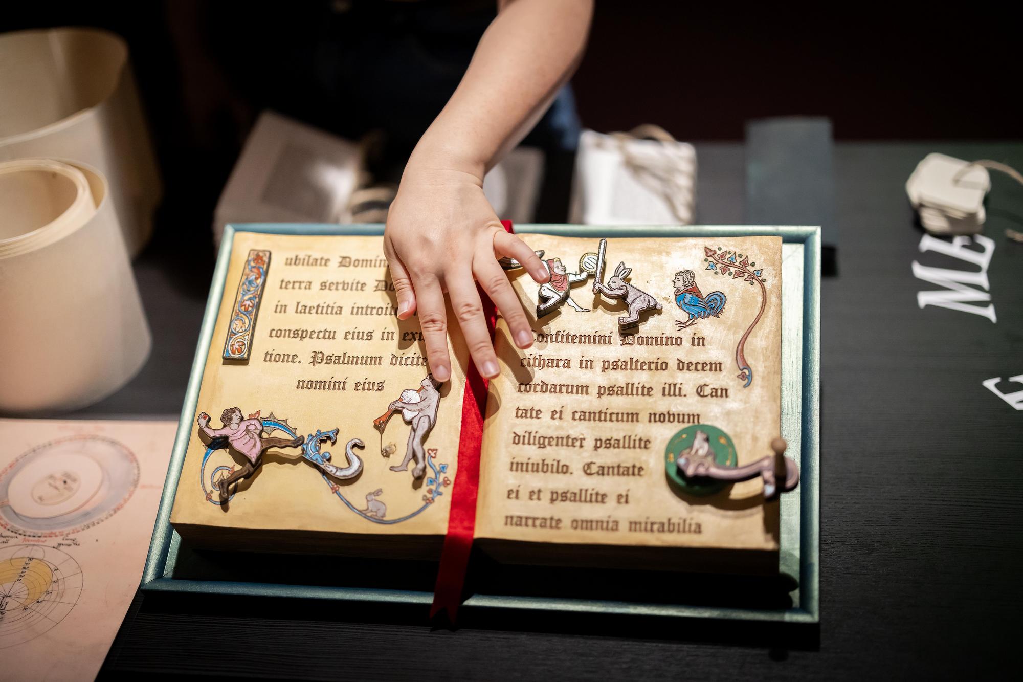 A laser-cut wooden book made to look like a medieval manuscript, with moveable figures