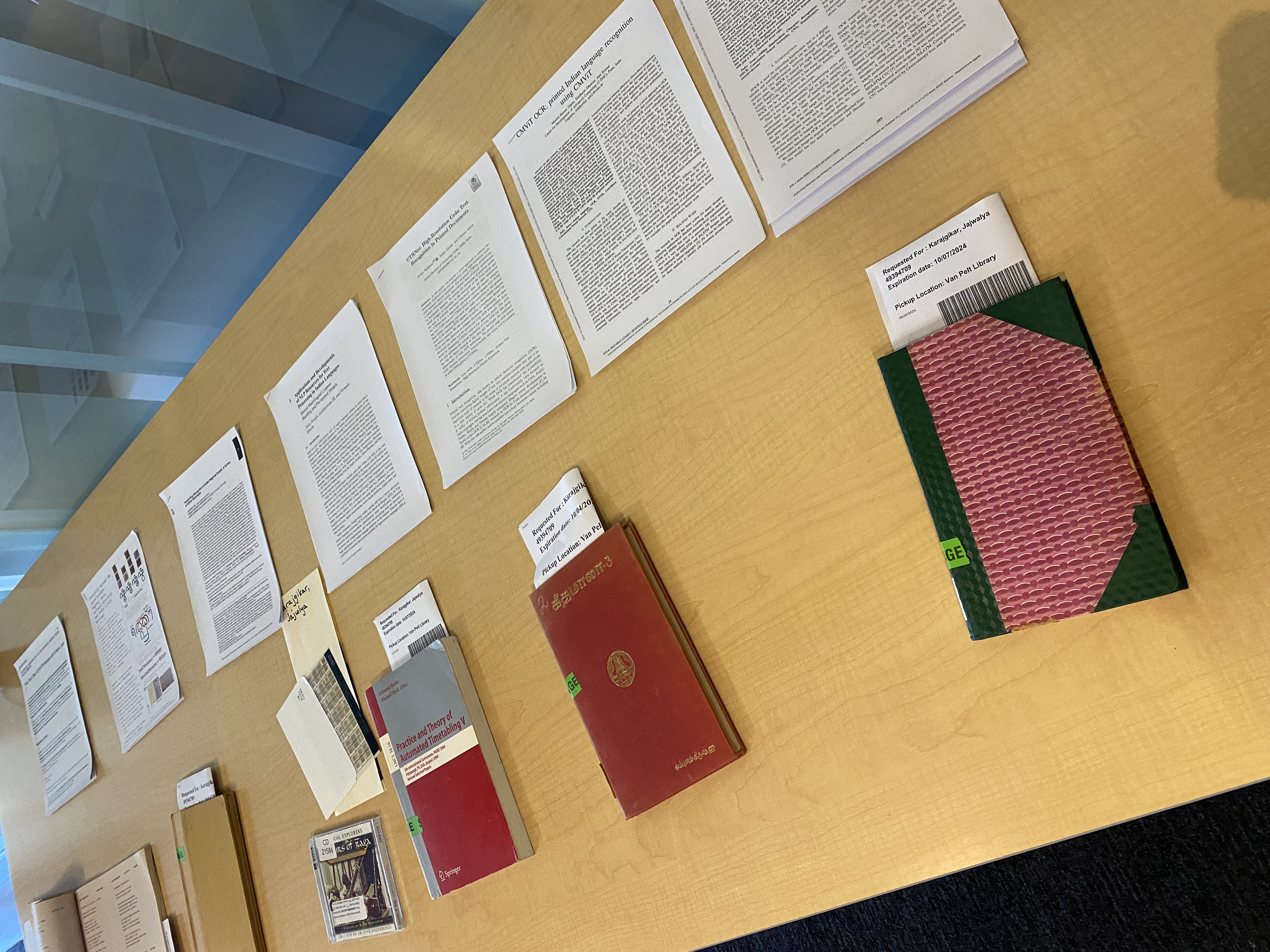 books and research papers on a yellow table