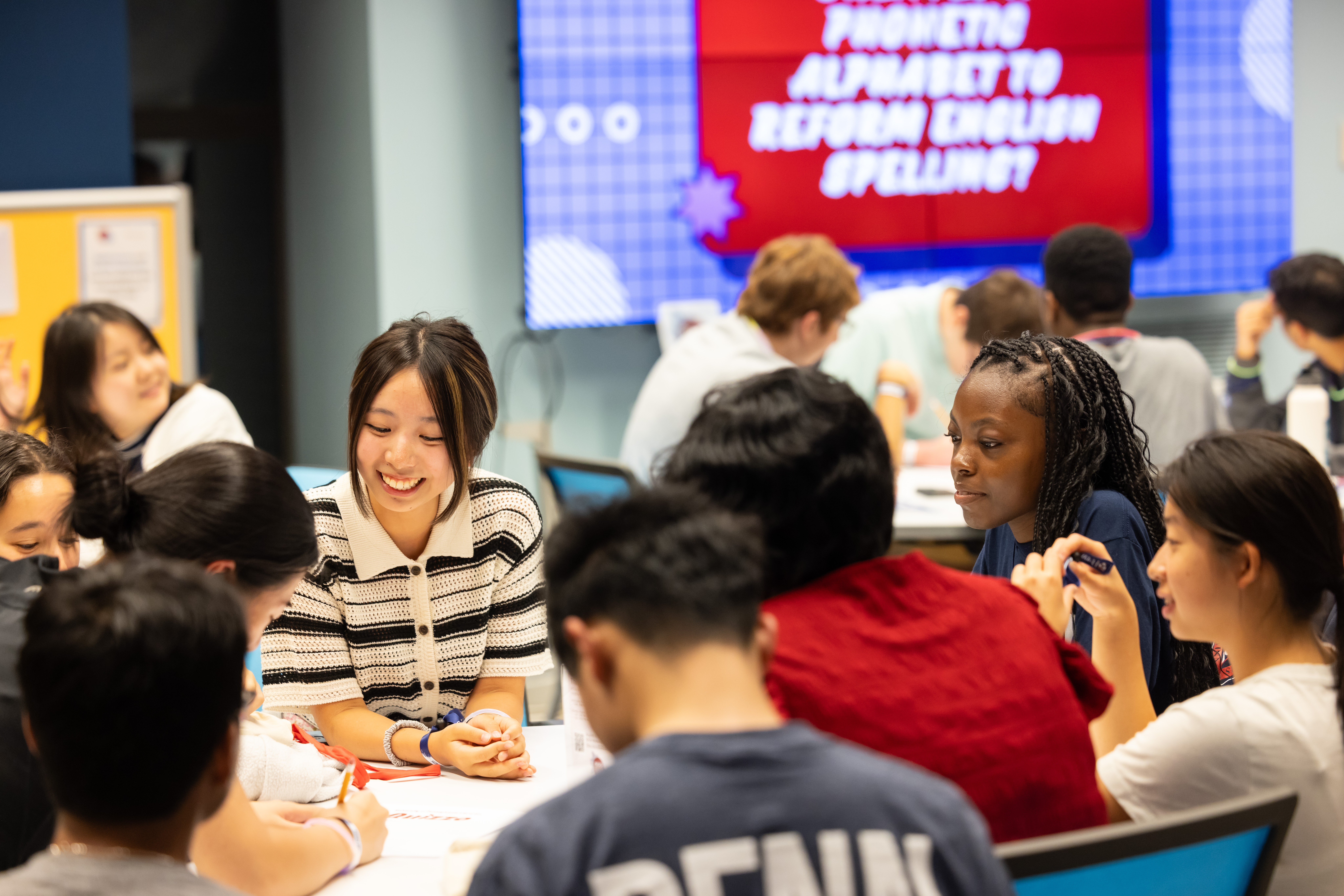Students gather around a table for activities during New Student Orientation