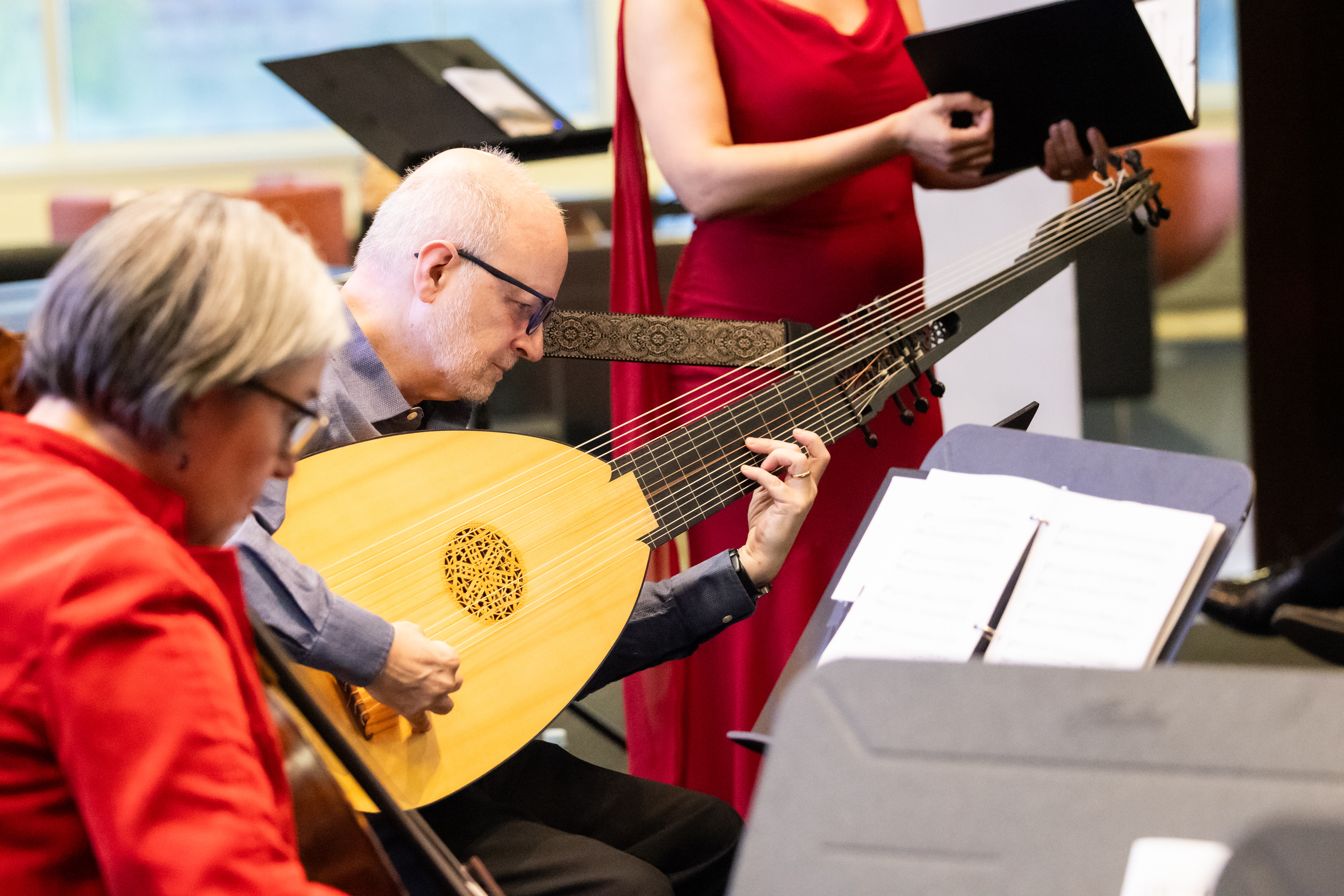 A man with glasses plays an instrument during a performance